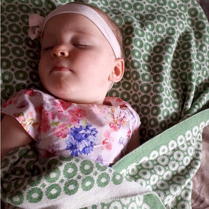 Baby girl wrapped in McKernan Baby Blanket Bubbles Green Earth